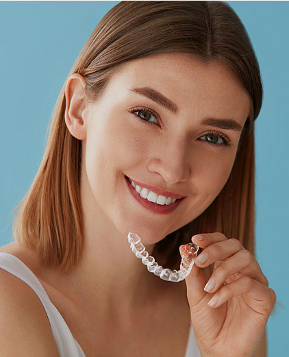 image of Portrait of beautiful patient holding orthodontic retainers in dental clinic