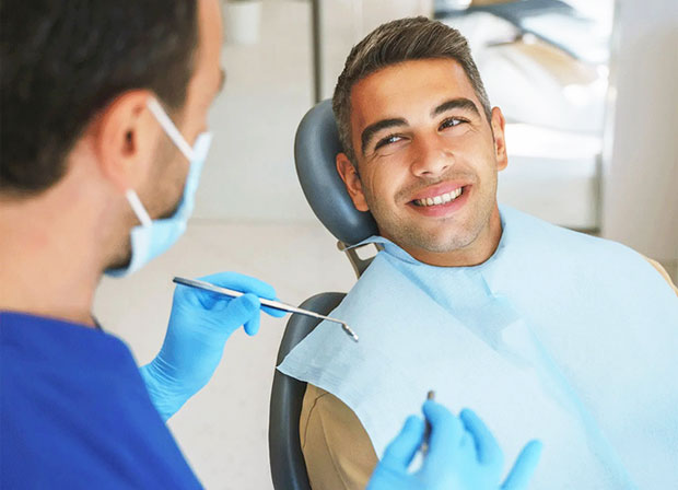 image of Young man patient having dental treatment at dentist's office