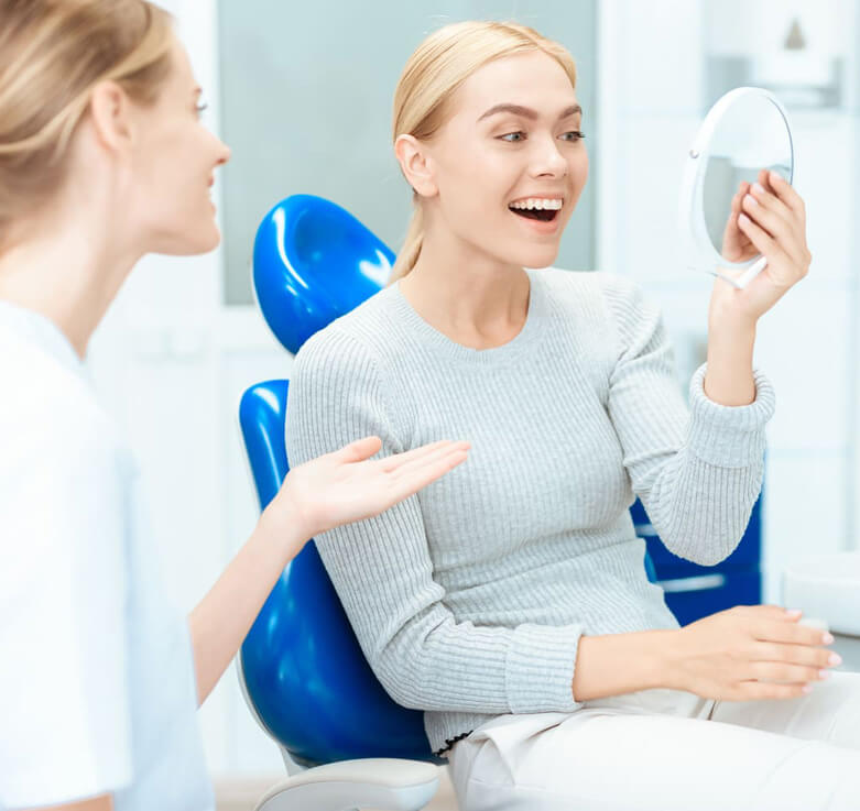 image of Dental patient smiles in mirror with dental bib