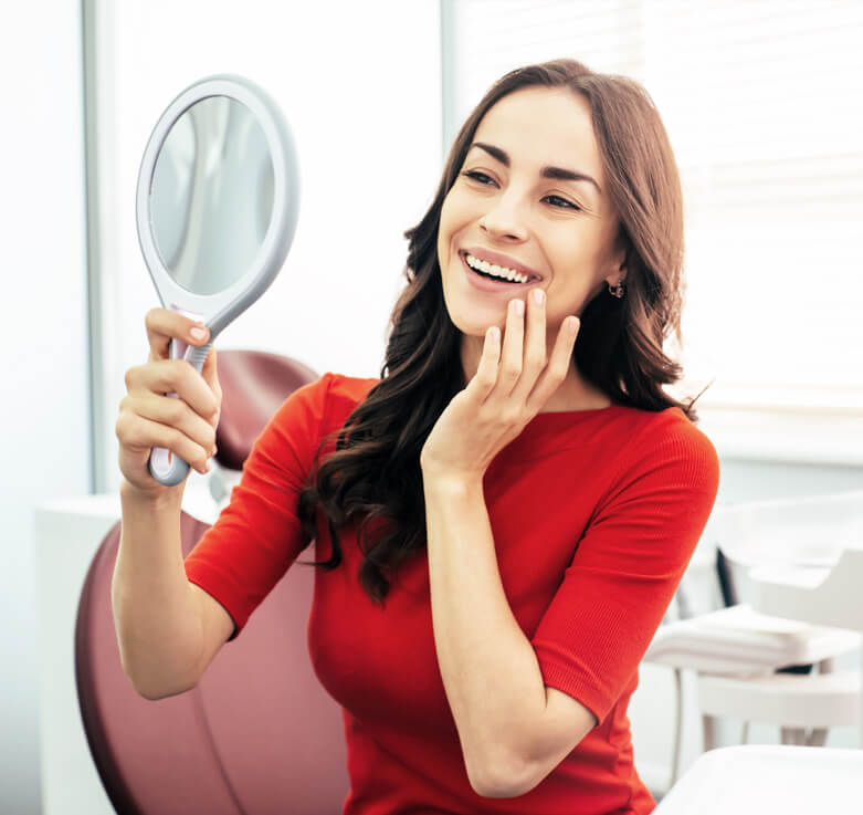 image of woman with a smile looks in the mirror